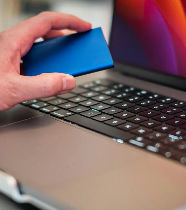 man-hand-holding-disk-over-laptop