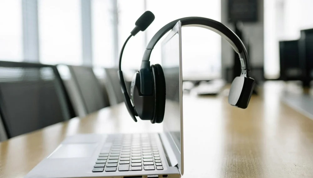 a-black-headset-microphone-hanging-on-the-laptop-screen