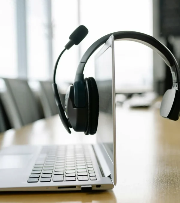 a-black-headset-microphone-hanging-on-the-laptop-screen